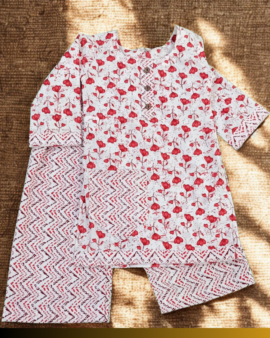 Flat lay red floral cotton kurti and pant set for baby girl