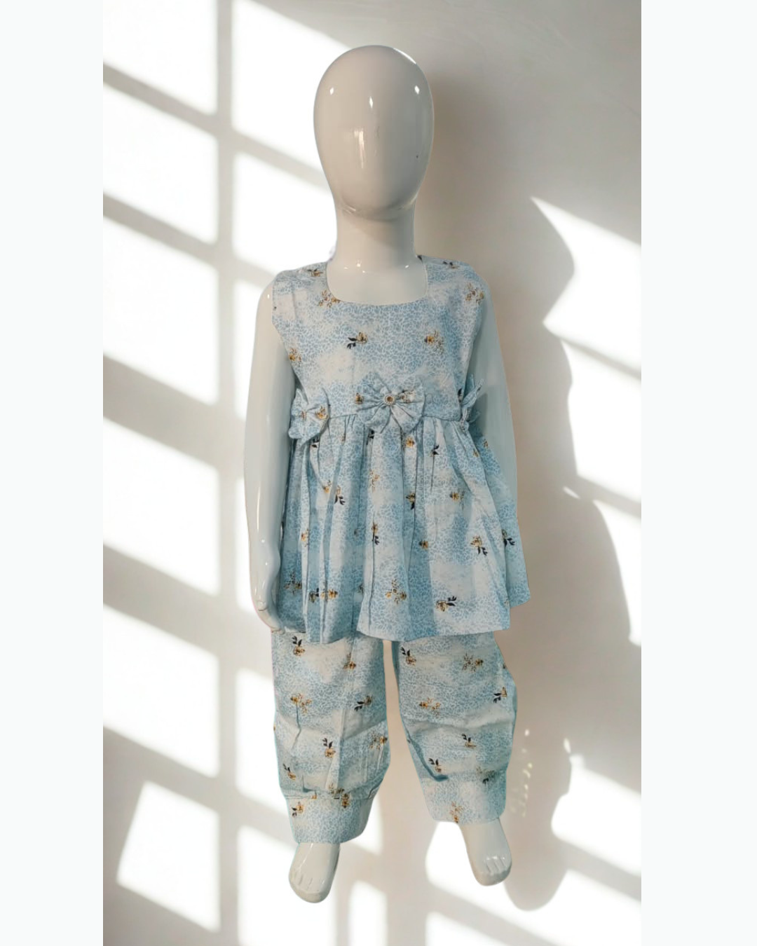 Asman baby girl kurti set, sky-blue and white base, small yellow floral print, sleeveless, gathered waist, 3 bows, matching pants - front view