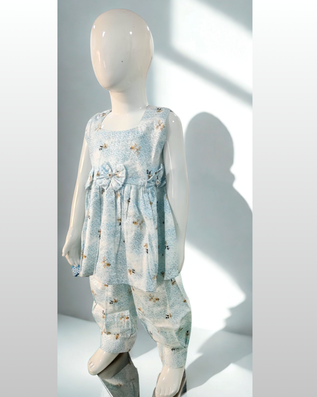 Asman baby girl kurti set, sky-blue and white base, small yellow floral print, sleeveless, gathered waist, 3 bows, matching pants - side view
