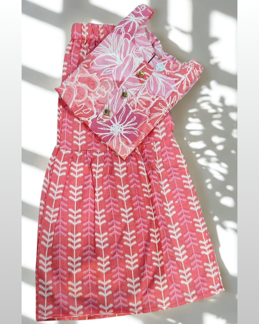 Gulfam baby girl kurti set, coral/salmon pink base, large white floral print, gold buttons, arrow-print palazzo - folded