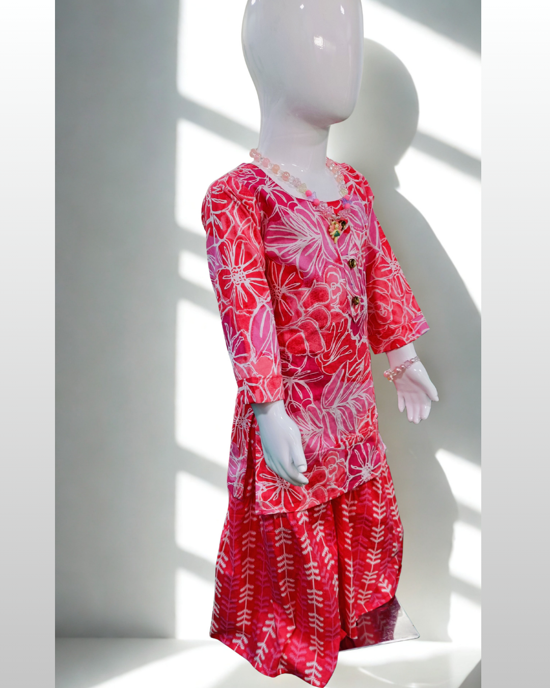 Gulfam baby girl kurti set, coral/salmon pink base, large white floral print, gold buttons, arrow-print palazzo - side view