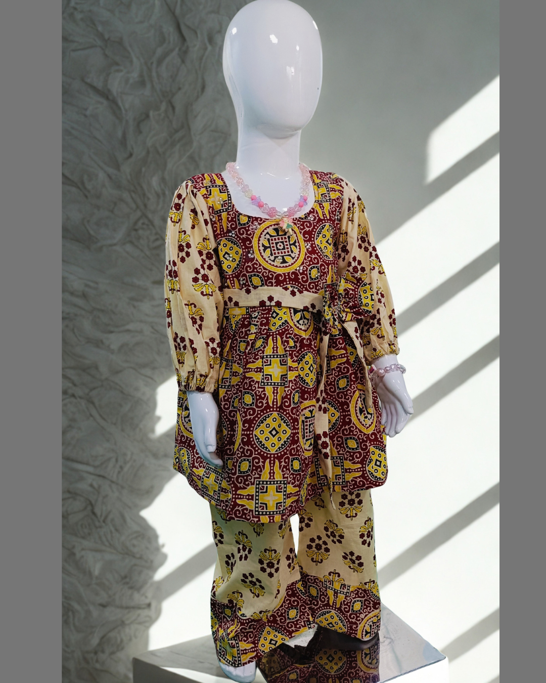 Gulnar baby girl kurti set, red and yellow on cream, bold geometric paisley print - front view