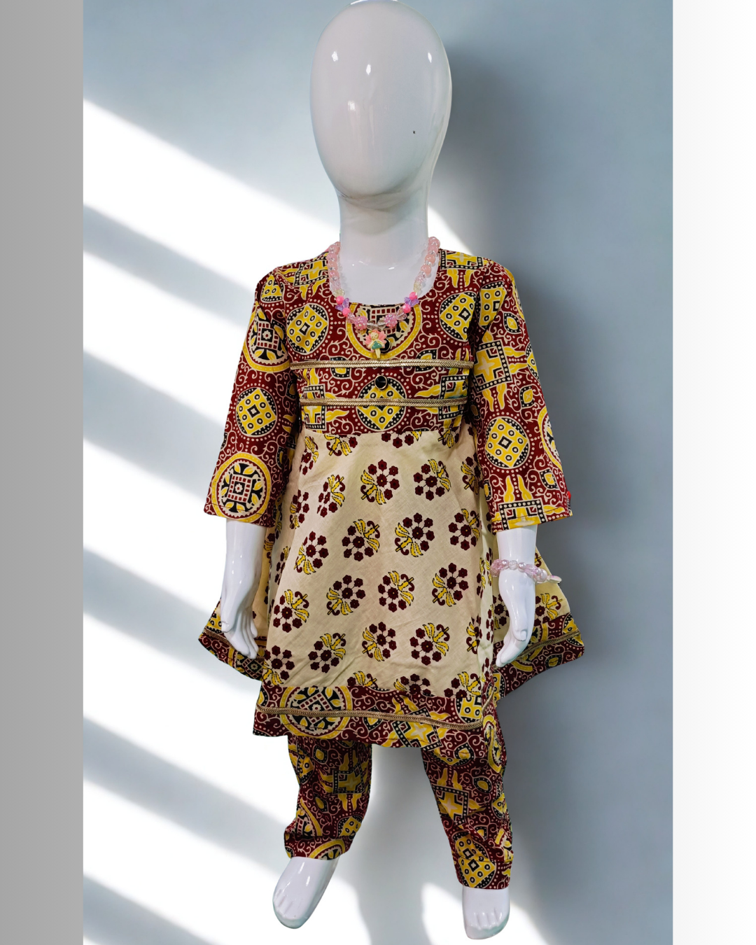 Kesari baby girl kurti set, cream base, red/yellow bold ajrakh geometric print, gold gota trim - front view