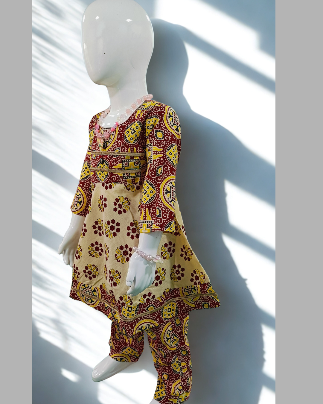 Kesari baby girl kurti set, cream base, red/yellow bold ajrakh geometric print, gold gota trim - side view