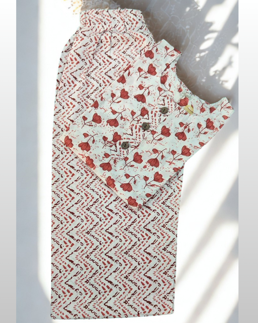Khushboo baby girl kurti set, white base, red tulip print, 3 buttons, chevron borders, red chevron pants - folded