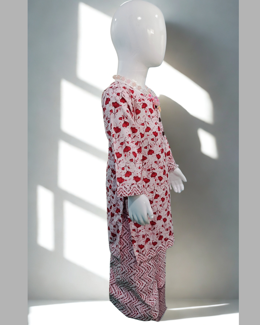 Khushboo baby girl kurti set, white base, red tulip print, 3 buttons, chevron borders, red chevron pants - side view