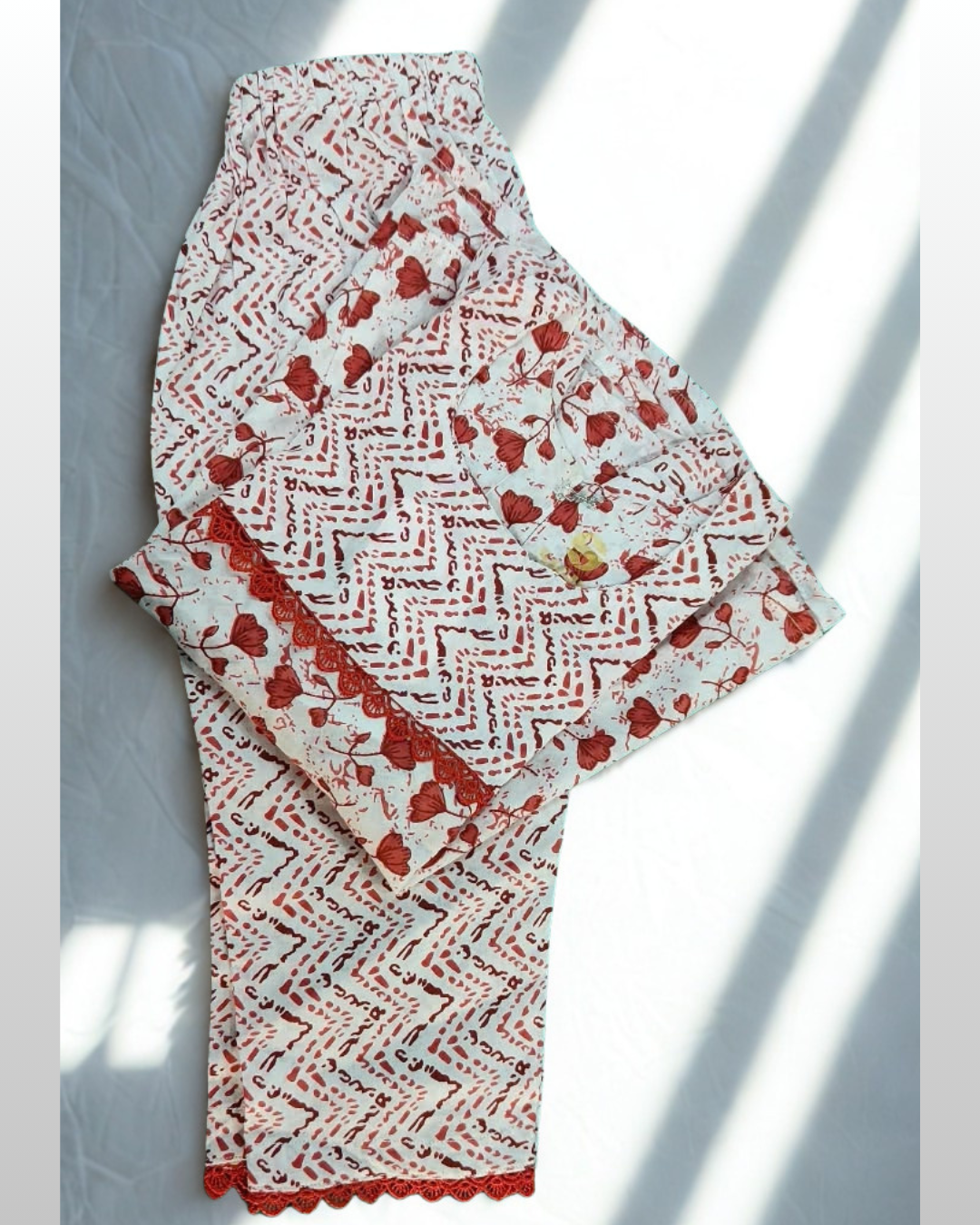 Laal Pari baby girl kurti set, white base, red abstract zigzag and floral print, red lace at waist - folded