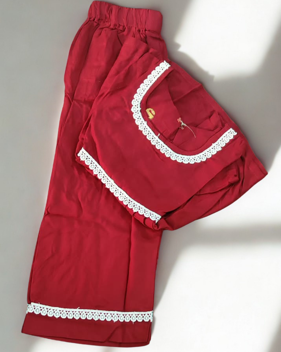 Laadli baby girl kurti set, crimson-maroon base, sleeveless, gathered waist, white lace on neckline, waist and pants hem - folded