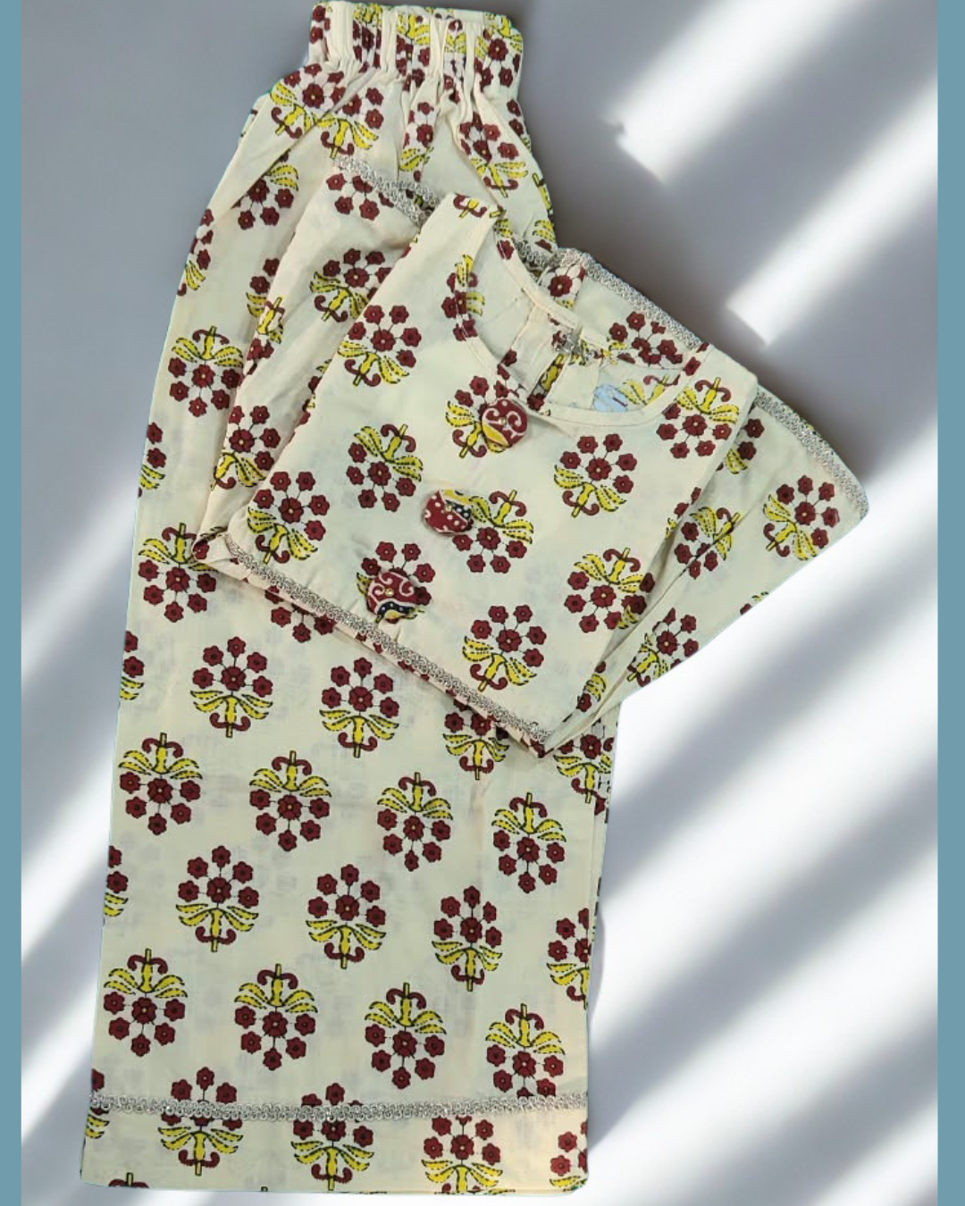 Parizaad baby girl kurti set, cream base, red-yellow floral block print, sleeveless, gathered waist, 3 buttons, gold braid, matching pants - folded