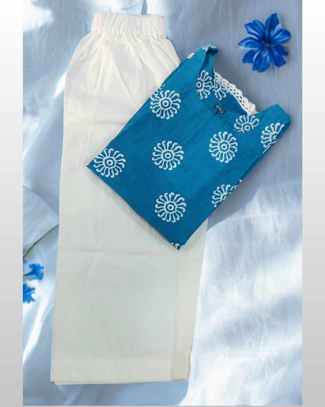 Roshni baby girl kurti set, blue base, white sun-motif print, square neckline, bell sleeves, white lace trim, white pants - folded