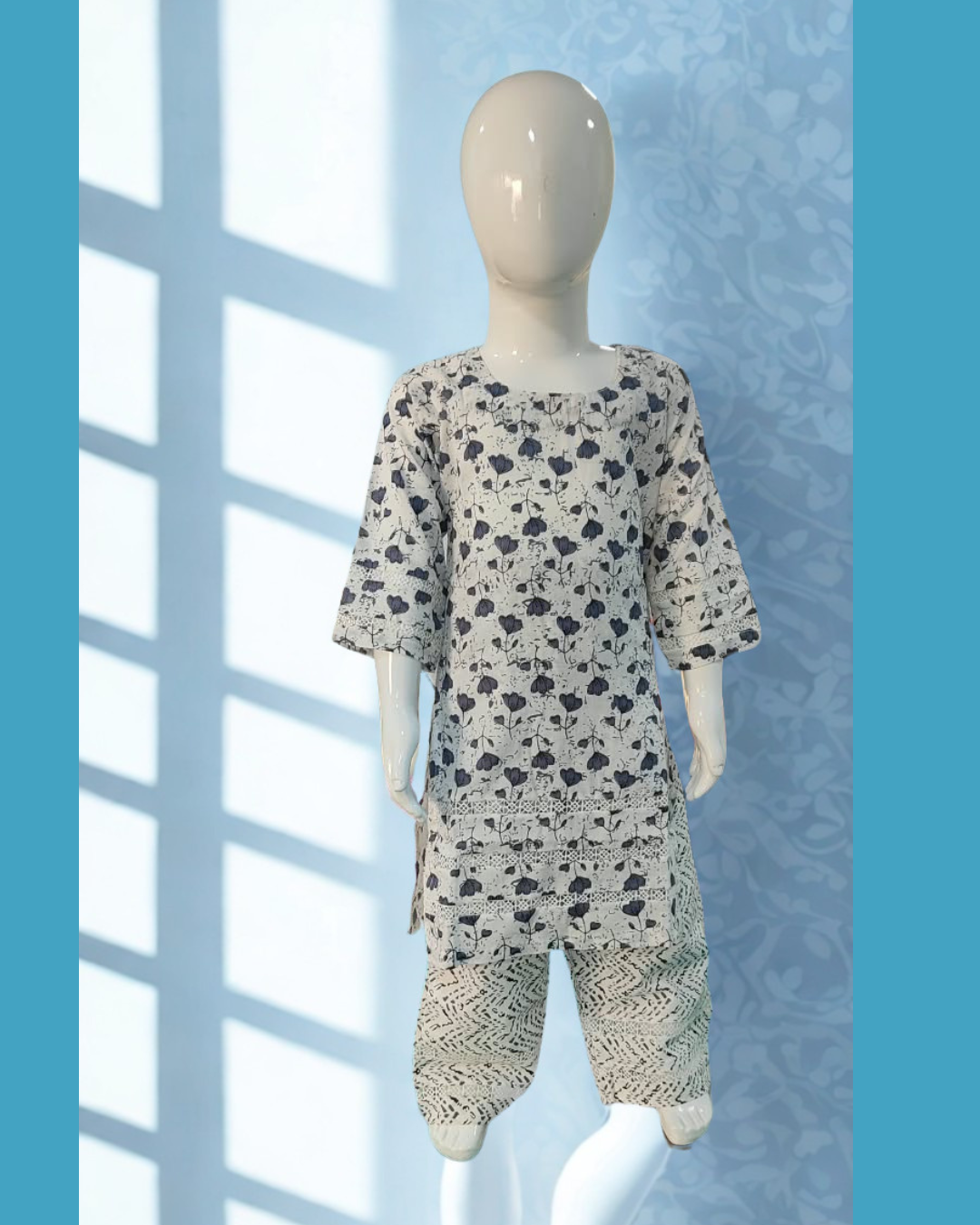 Shabana baby girl kurti set, white base, grey tulip print, three rows of cutwork lace, lace sleeve bands, grey chevron-print pants - side view