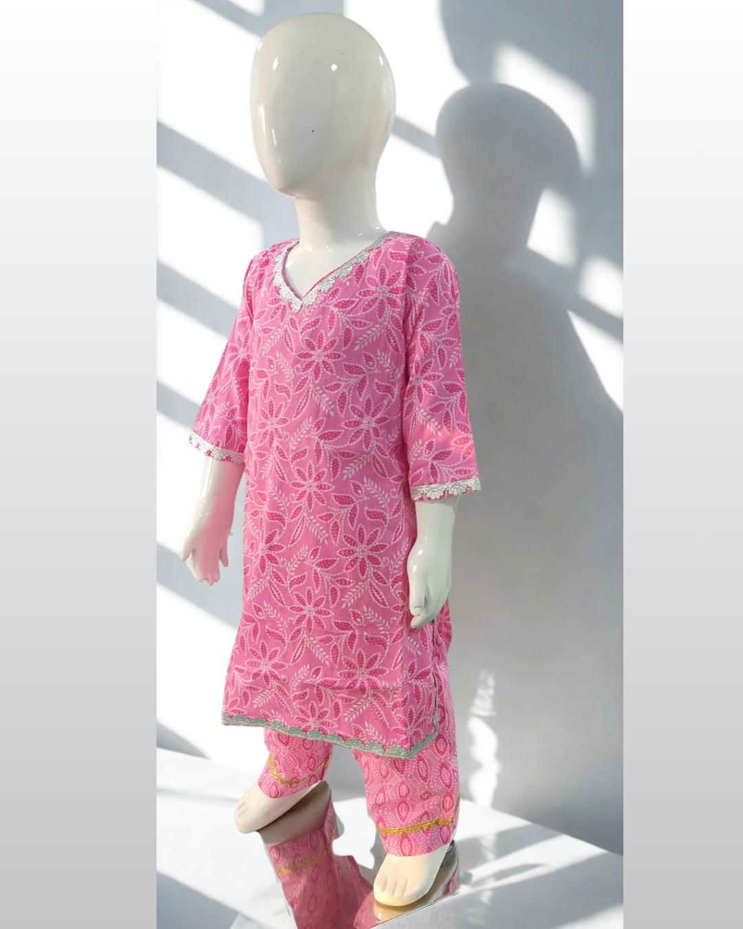 Yasmeen baby girl kurti set, soft pink base, white leaf-floral print, silver gota lace on V-neckline, sleeves and hem, oval-print pants - side view