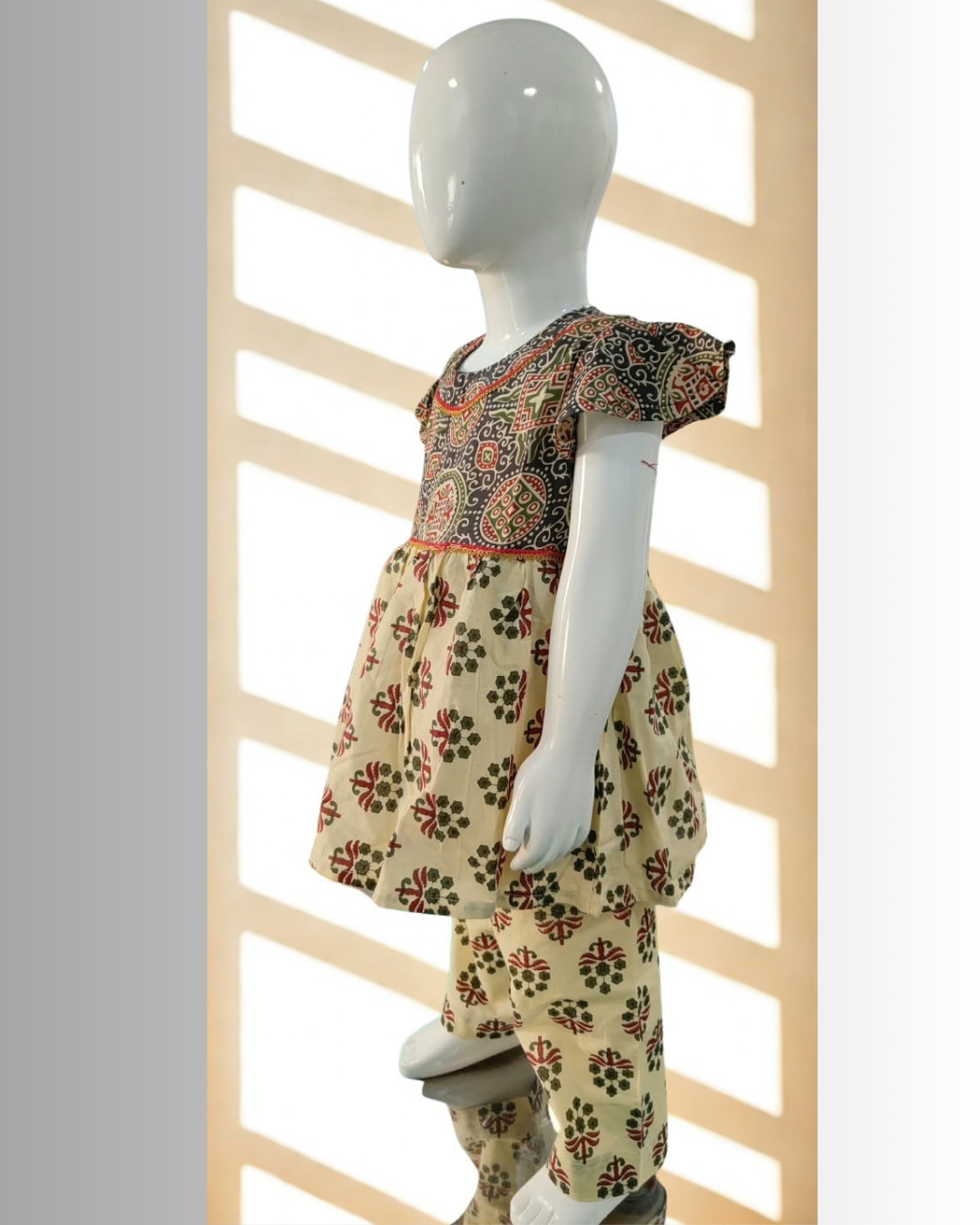 Zardozi baby girl kurti set, black base, bold ajrakh paisley print, red neckline trim - side view